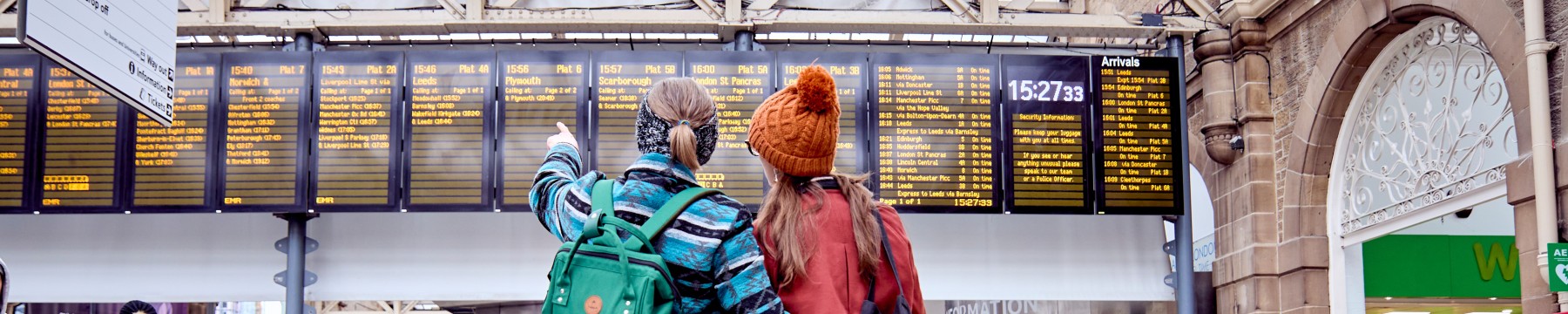 Two passengers pointing at the information boards